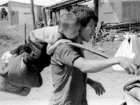 Description: A South Vietnamese Father Carries His Son and a Bag of Household Possessions Photographic Print